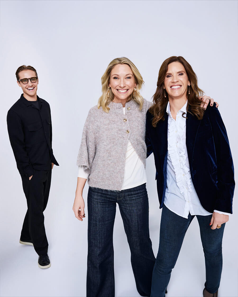 Två kvinnor och en man ler mot kameran